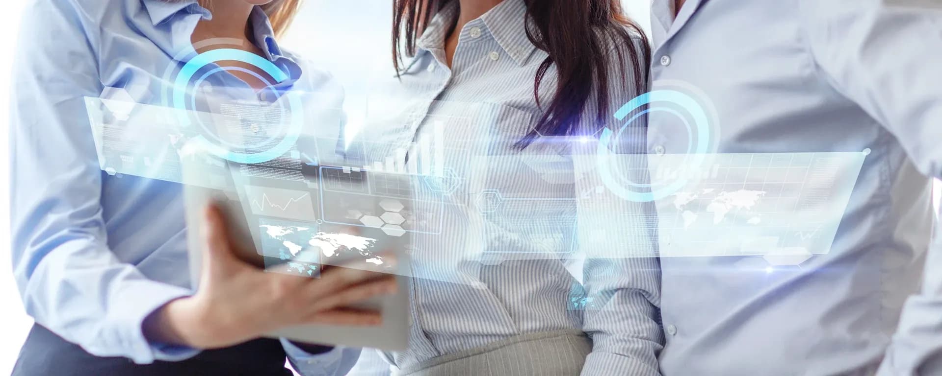 Personas trabajando frente a un ipad con gráficos holográficos a su alrededor.